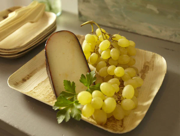 7-8.5-inch Disposable Rectangle Palm Leaf Plate shown with cheese and grapes