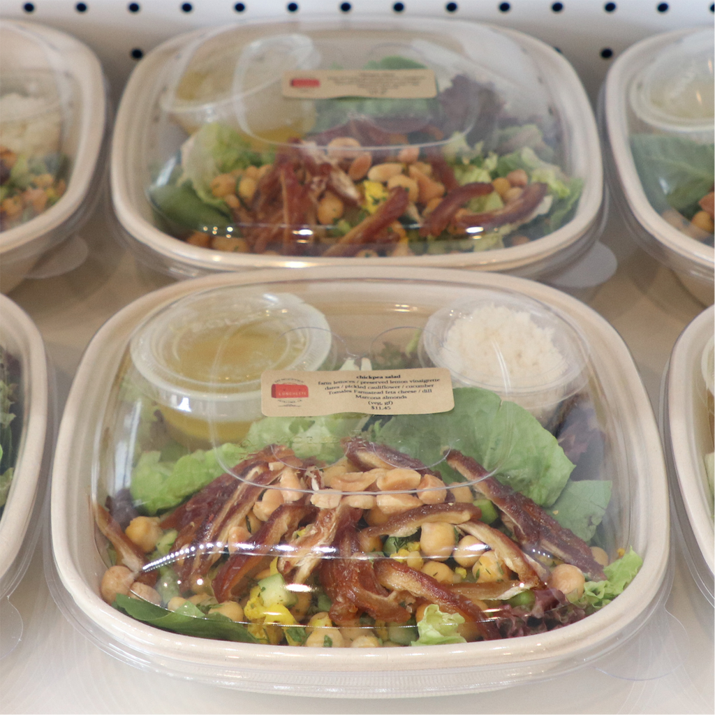 World Centric 24 oz Compostable Square Bowl with Lid shown with prepared salad.