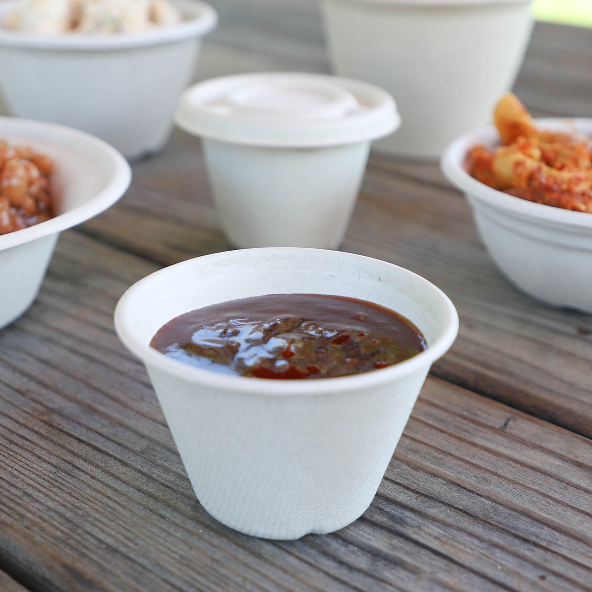World Centric 4 oz Fiber Souffle Cup shown with a condiment